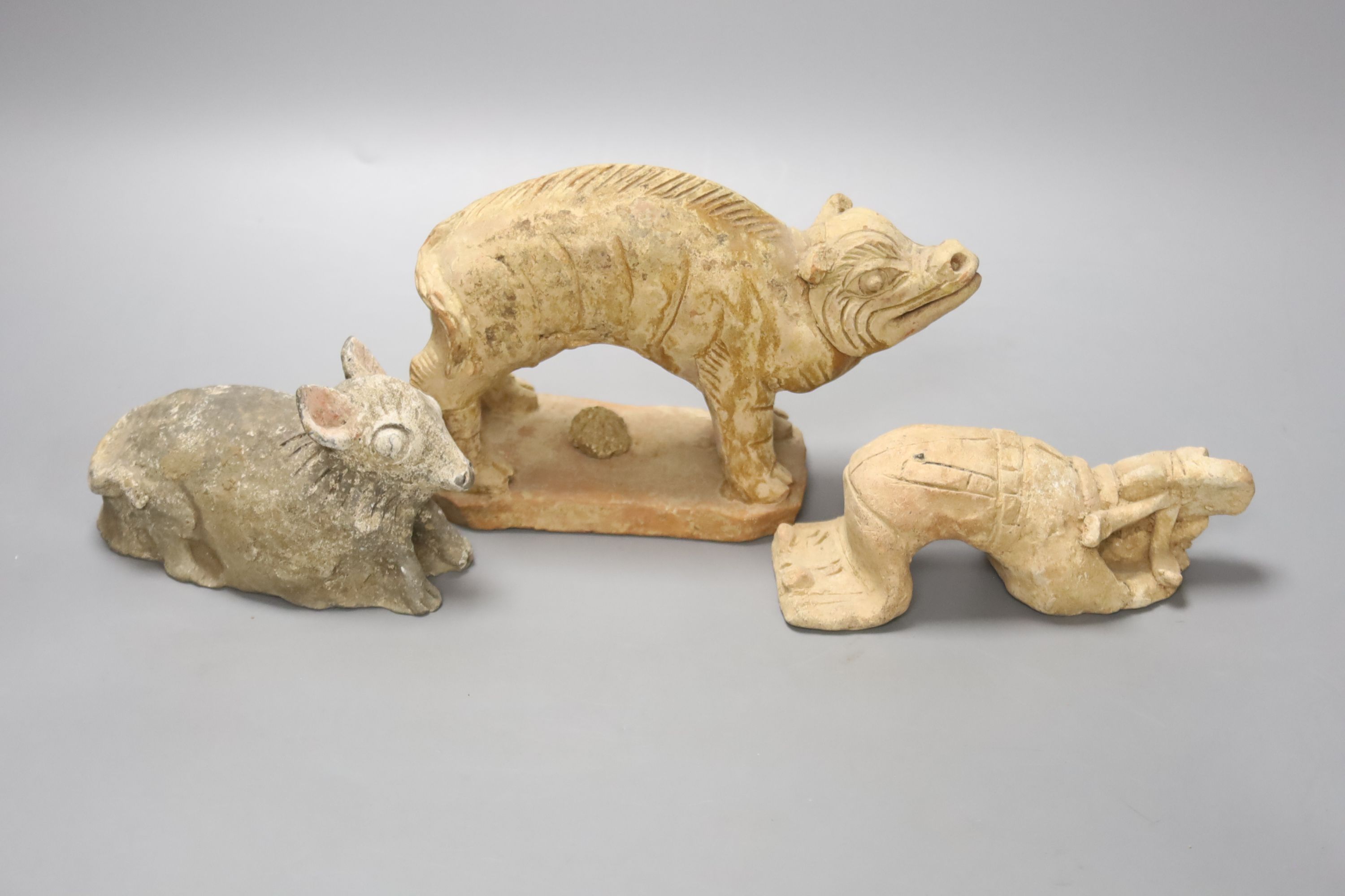A Chinese Han terracotta model of a standing pig, 17cm long 12cm high, together with two further modelled terracotta figures and a small white glazed Chinese porcelain footed dish, diameter 14cm 4cm high